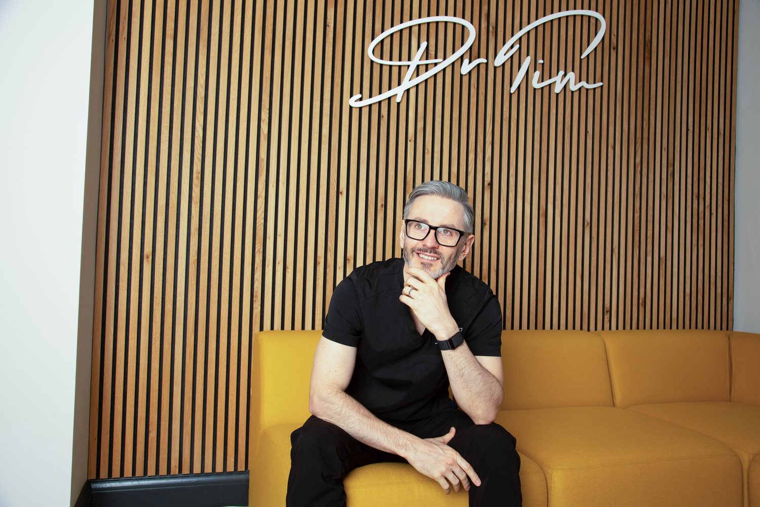 Dr Tim Pearce beneath his signature wall in the Profinity Wellness clinic