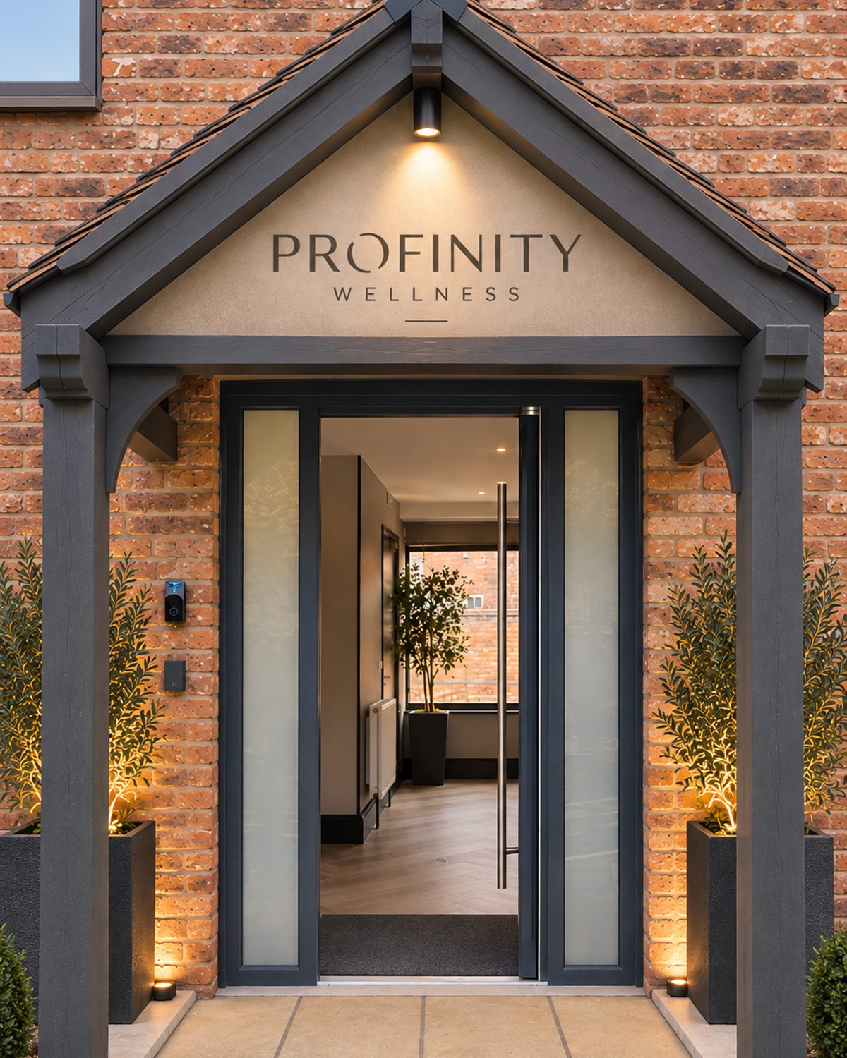 The entrance to Profinity Wellness in Holmes Chapel, lit at dusk with the door open