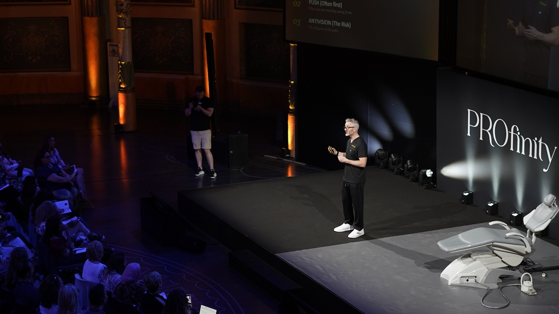 Dr Tim Pearce teaching from the stage to a seated audience of clinicians at the Profinity Clinic Growth Summit in Rome